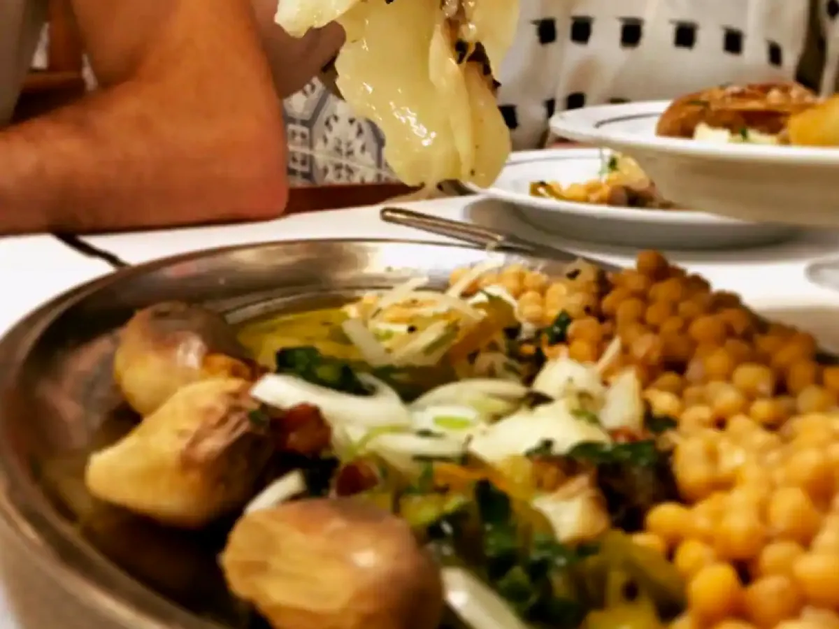 a woman sitting at a table with a plate of food