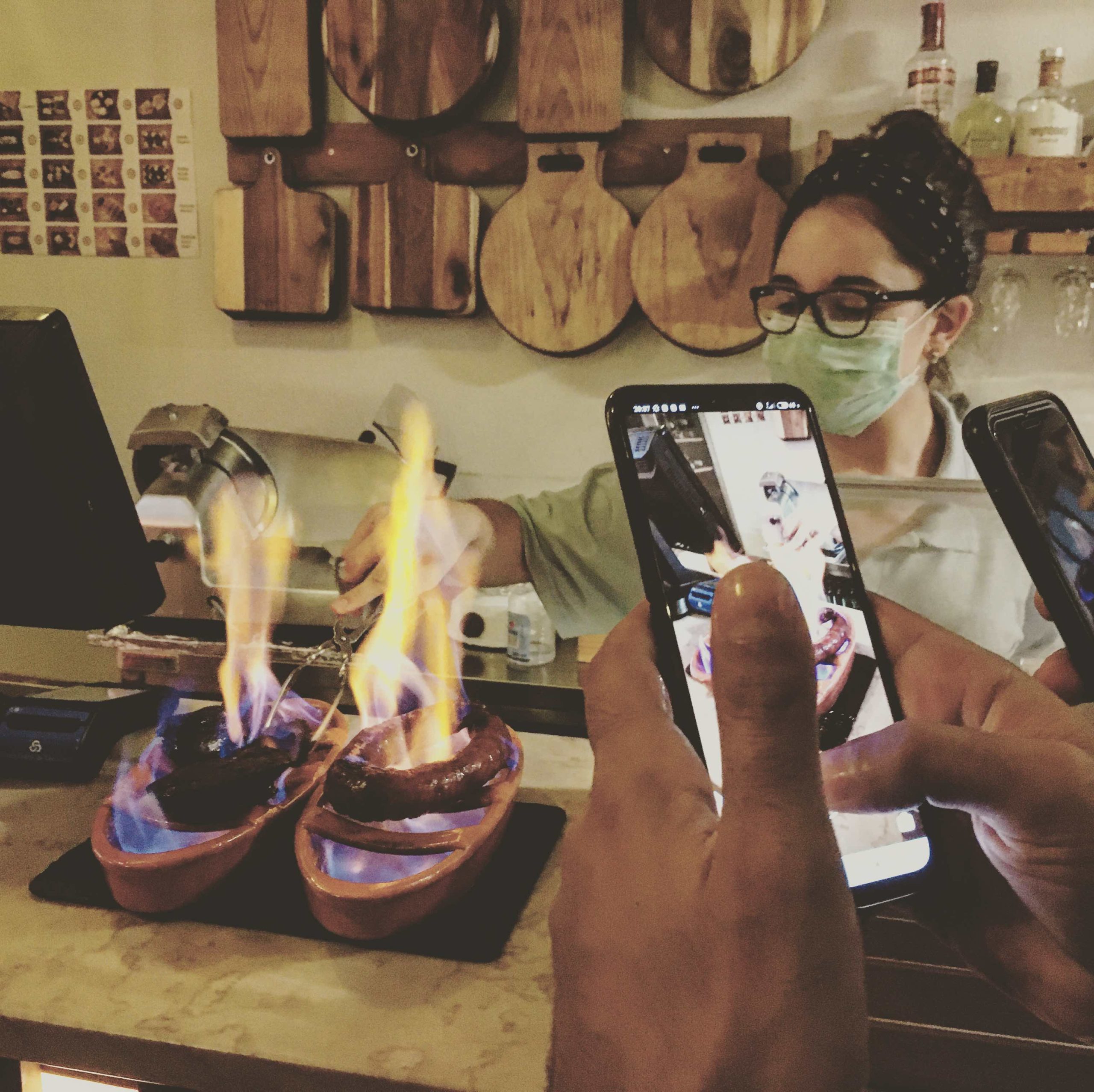 chorizo being grilled waitress with mask protection