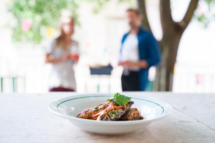 a person sitting at a table with a plate of food with broccoli