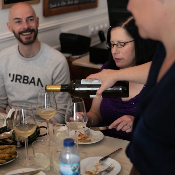 a group of people sitting at a table with wine glasses