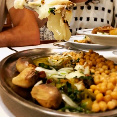a woman sitting at a table with a plate of portuguese codfish