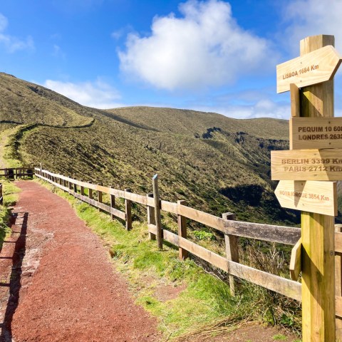 a wooden bench on the side of a mountain