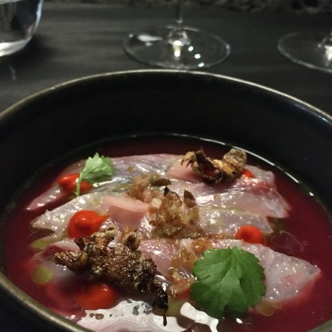 a bowl of soup with meat and vegetables on a plate