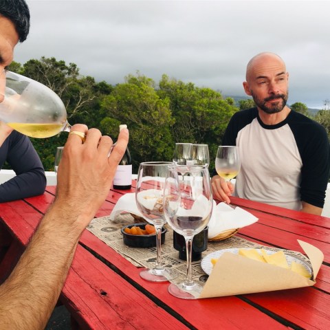 a man sitting at a table with wine glasses