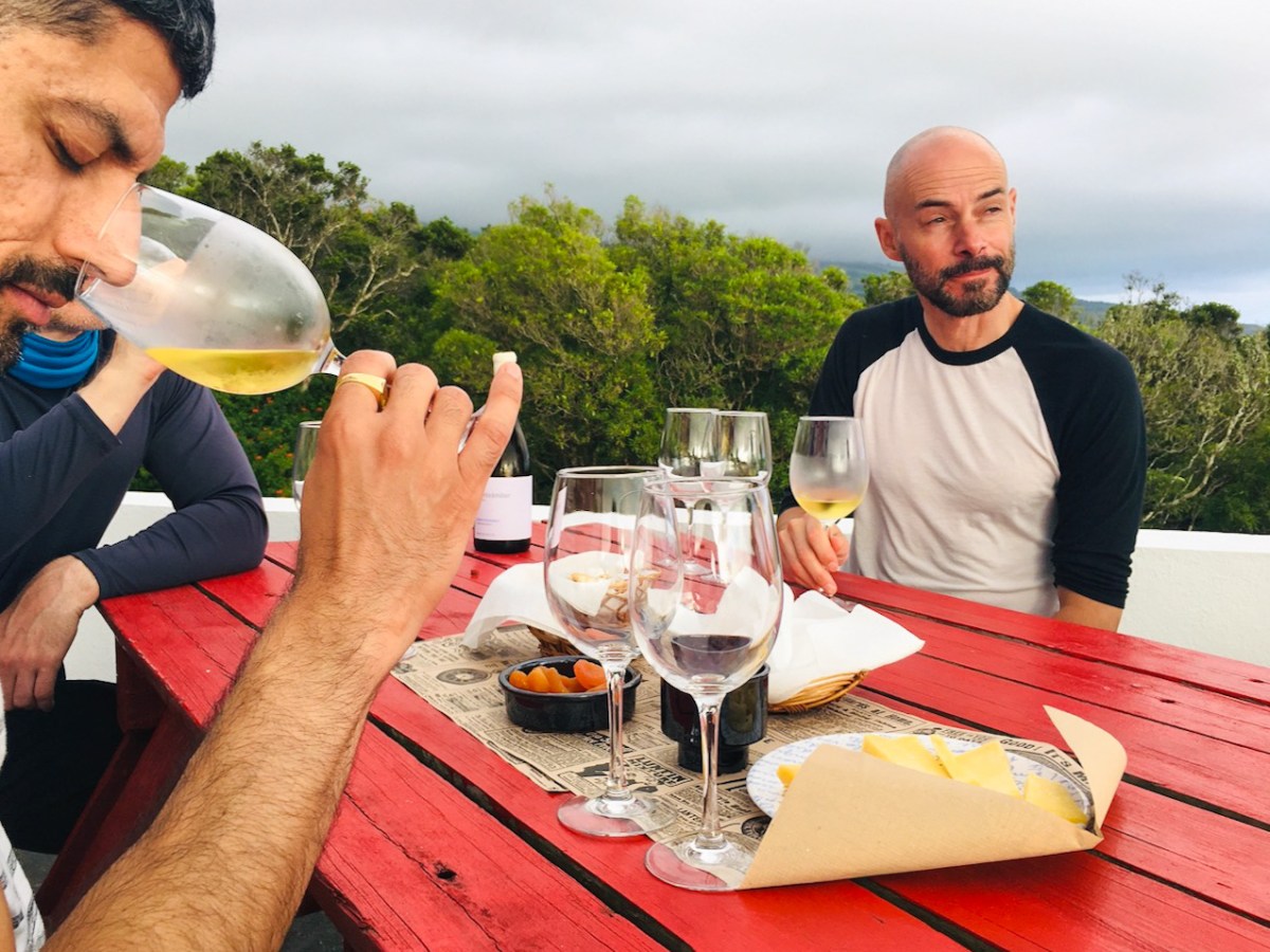 a man sitting at a table with wine glasses