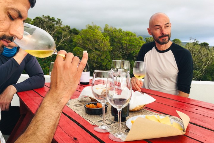 a man sitting at a table with wine glasses