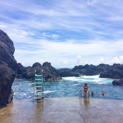 a group of people standing next to a body of water