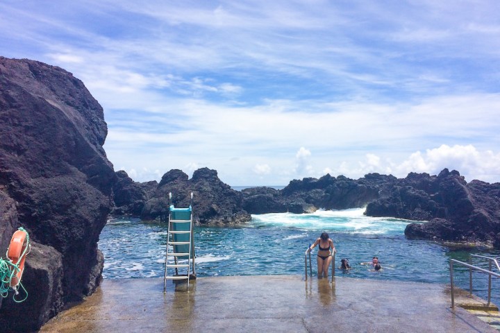 a group of people standing next to a body of water