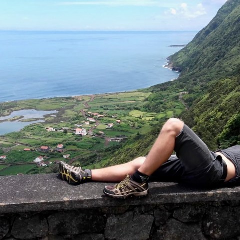 a person sitting on a bench next to a body of water