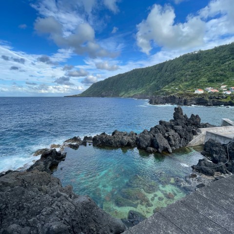 a large body of water with a mountain in the background