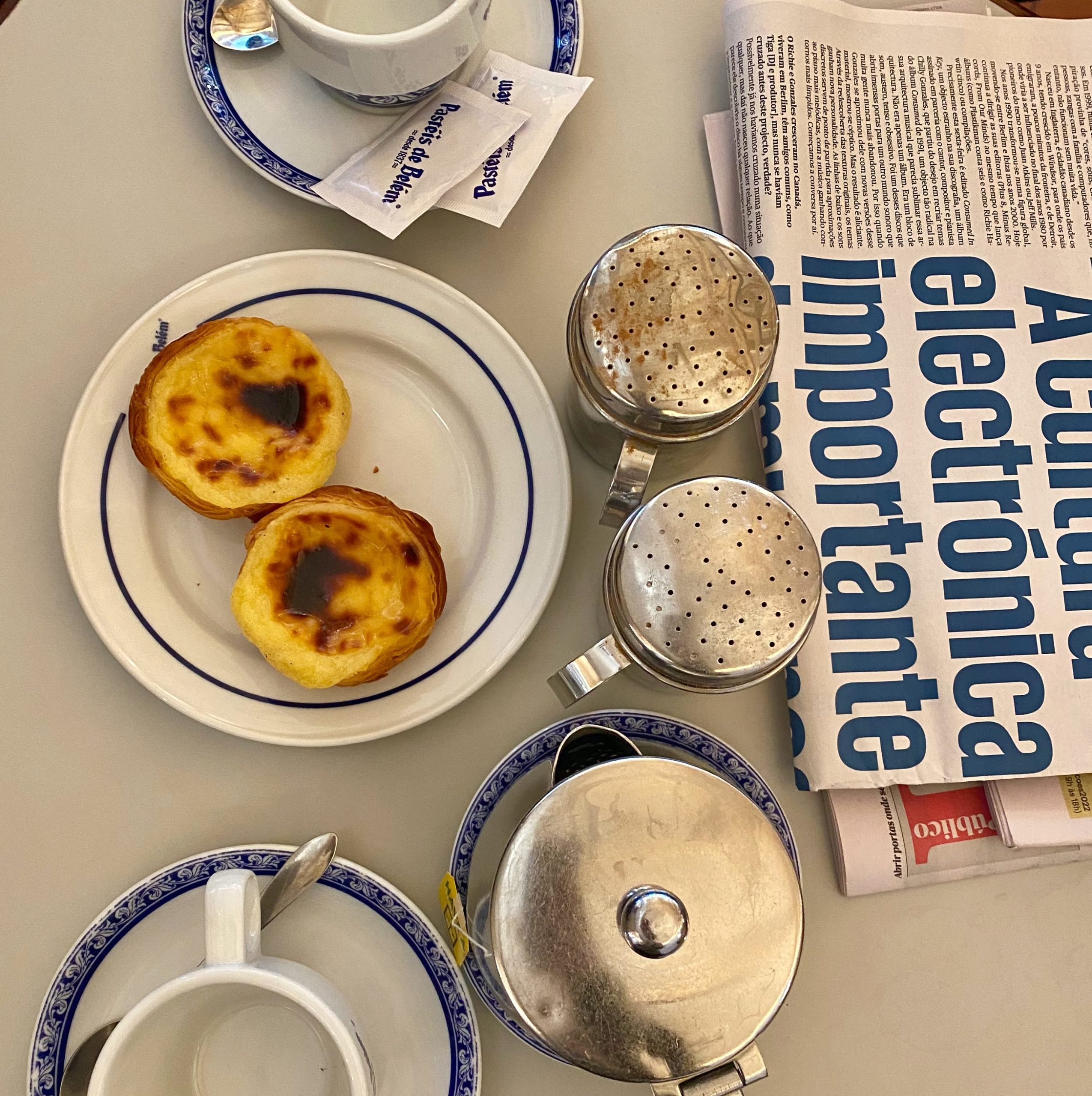 two cakes on a plate with cinamon powder and a newpaper