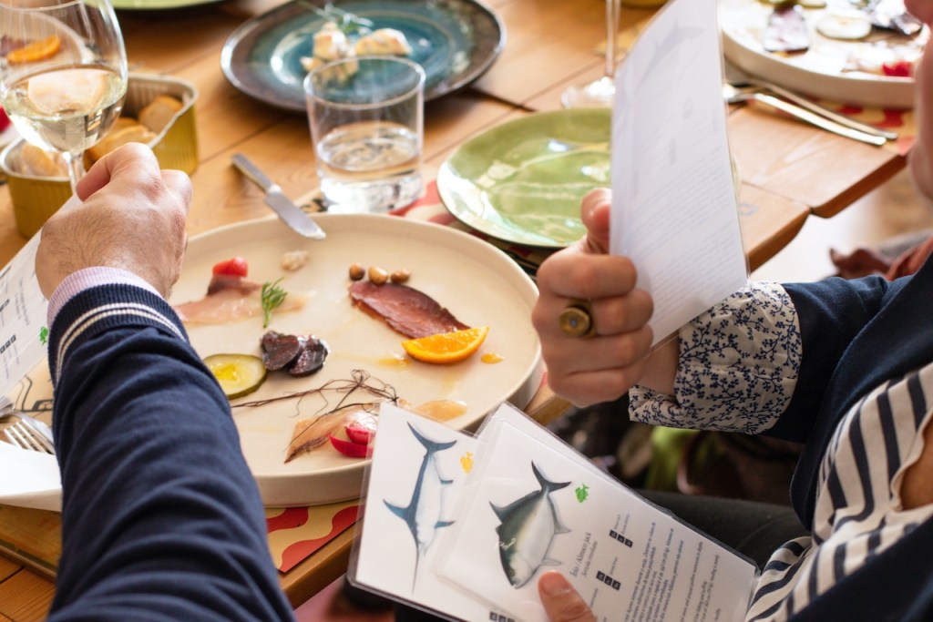 a group of people sitting at a table with a plate of food