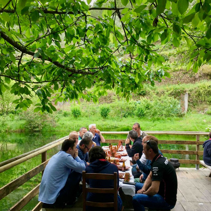 a group of people sitting on a bench in a park eating