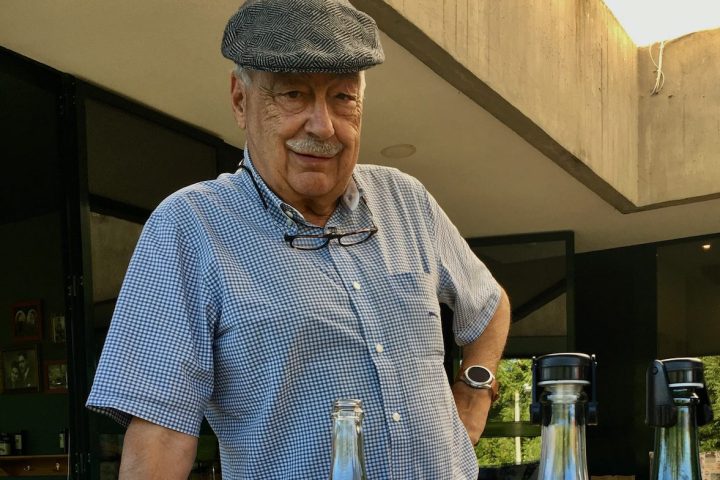 a man sitting at a table with wine glasses