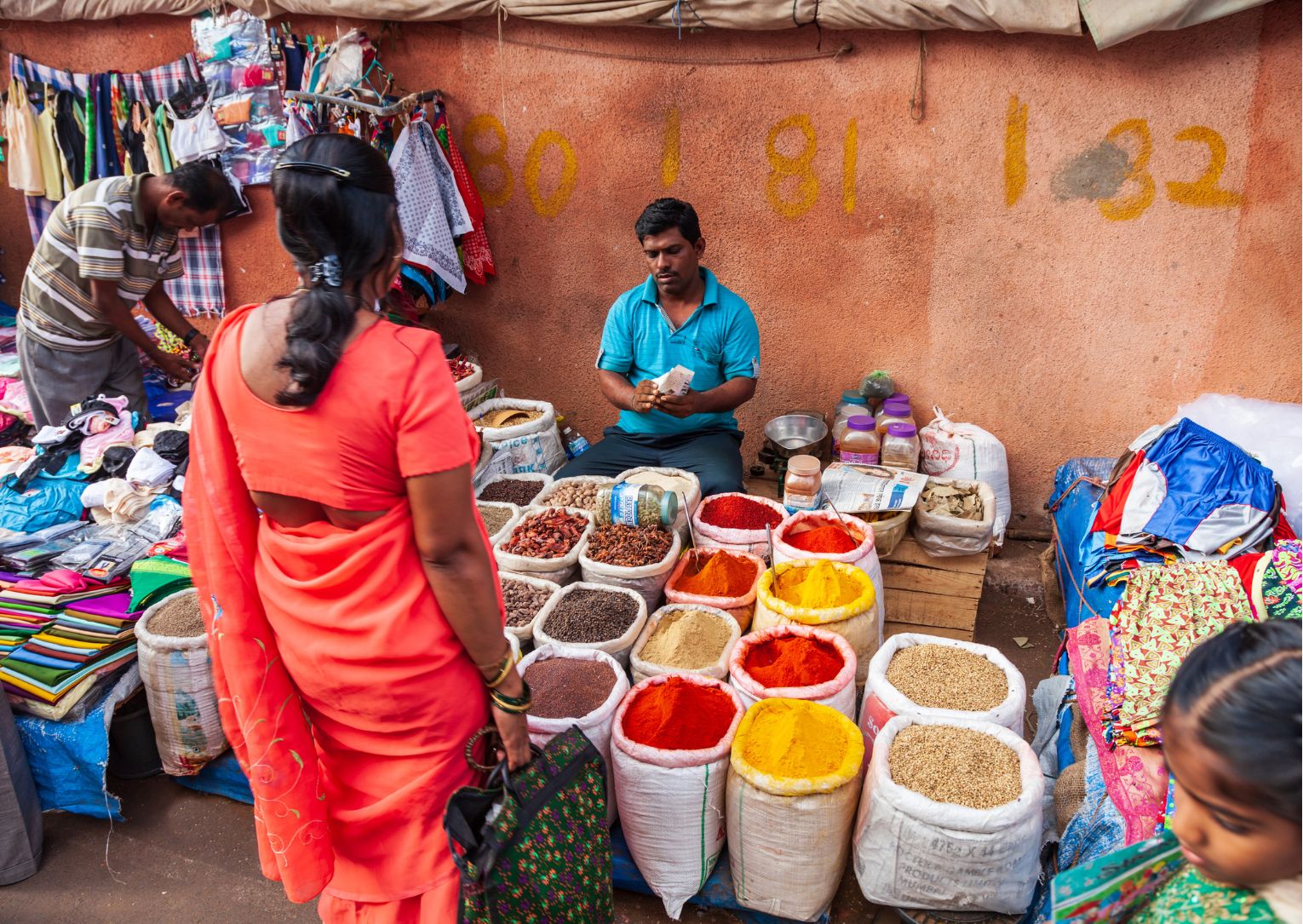 a group of people sitting at a fruit stand