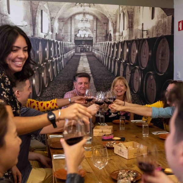 a group of people are drinking from a wine glass