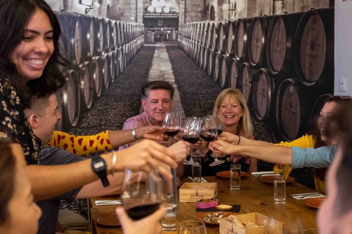 a group of people are drinking from a wine glass