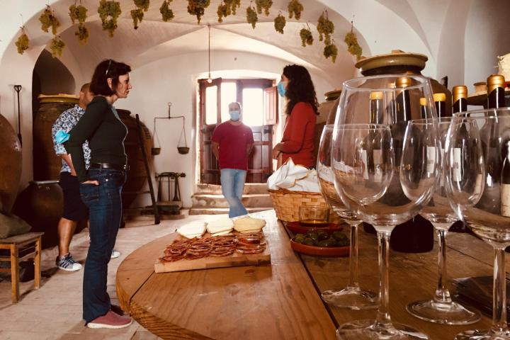 a person sitting at a table with wine glasses