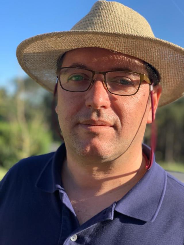 rodrigo-ohmycod-food-cultural-host a close up of a man wearing a hat and glasses