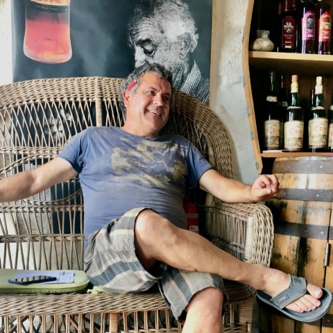 a man standing next to a bottle of wine