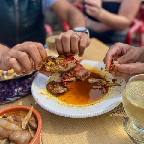 a group of people sitting at a table with a plate of food