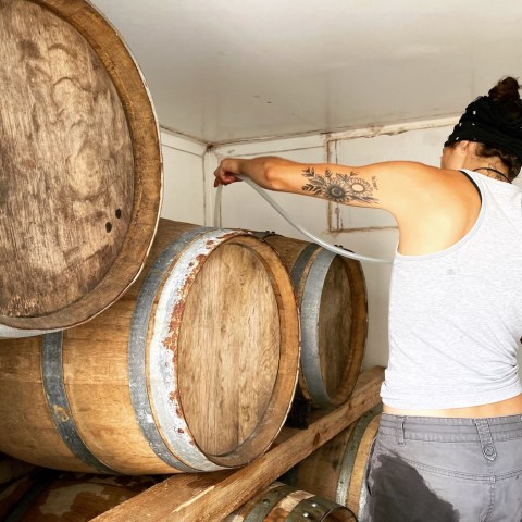 a woman standing in front of a barrel