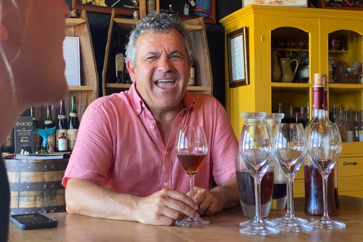a person sitting at a table with wine glasses