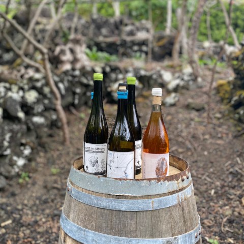 a bottle of wine sitting on top of a barrel