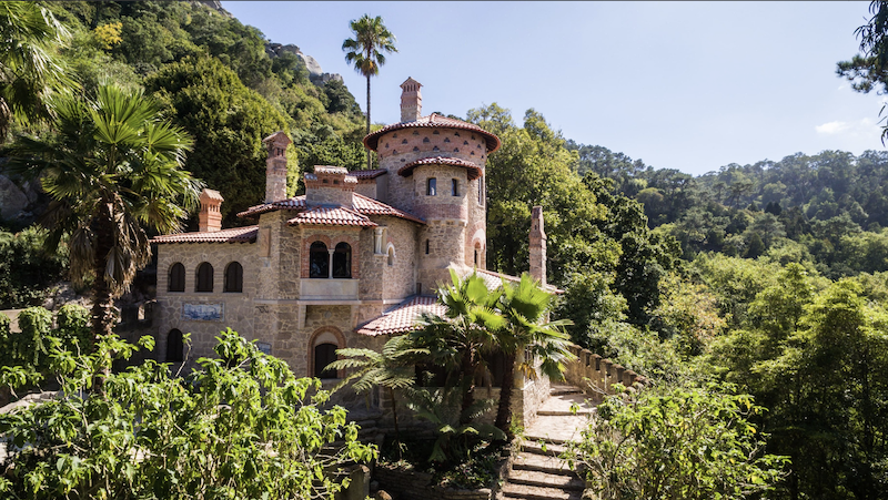 a house with bushes in front of a castle