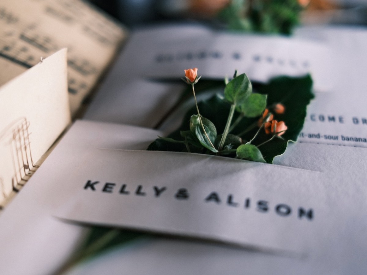 Close-up of names on envelopes with small flowers and leaves inserted.