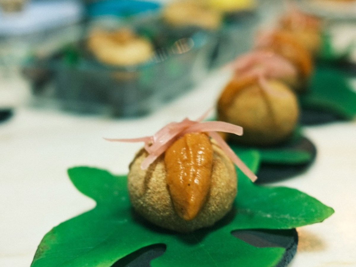 Gourmet dish on leaf-shaped plates with sauce and garnish.