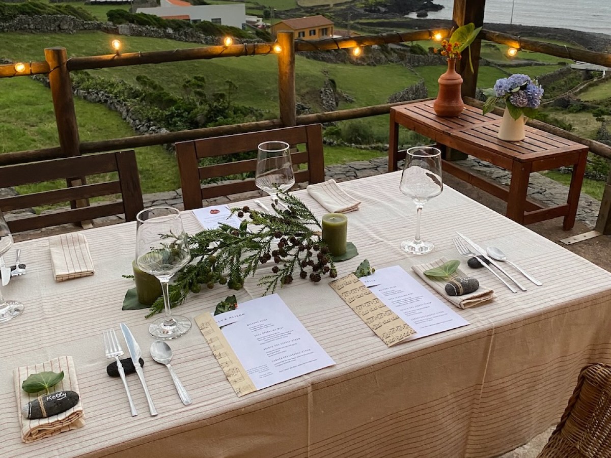 Outdoor dining table set elegantly with menus and ocean view.